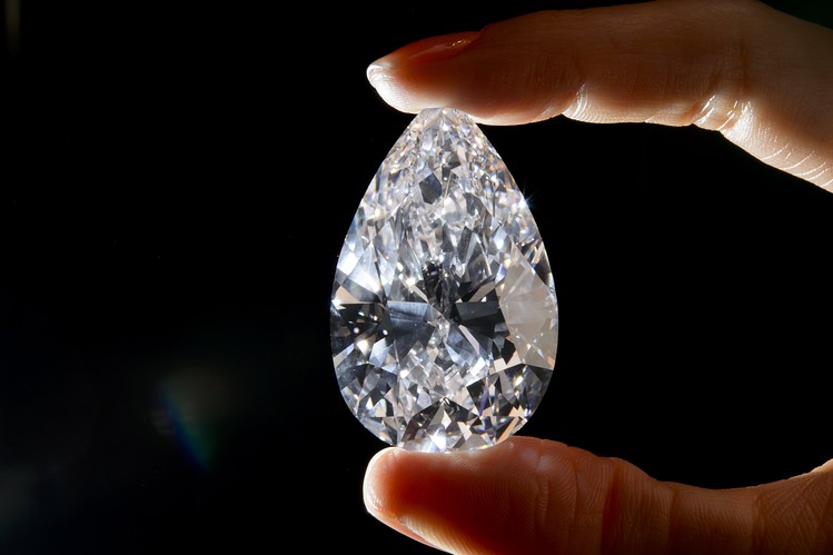 A model holds a diamond weighing 101.73 carats ahead of a sale May 15, 2013, by Christie's auction house in Geneva. The raw stone, weighing 236 carats, was extracted from a mine in Botswana.